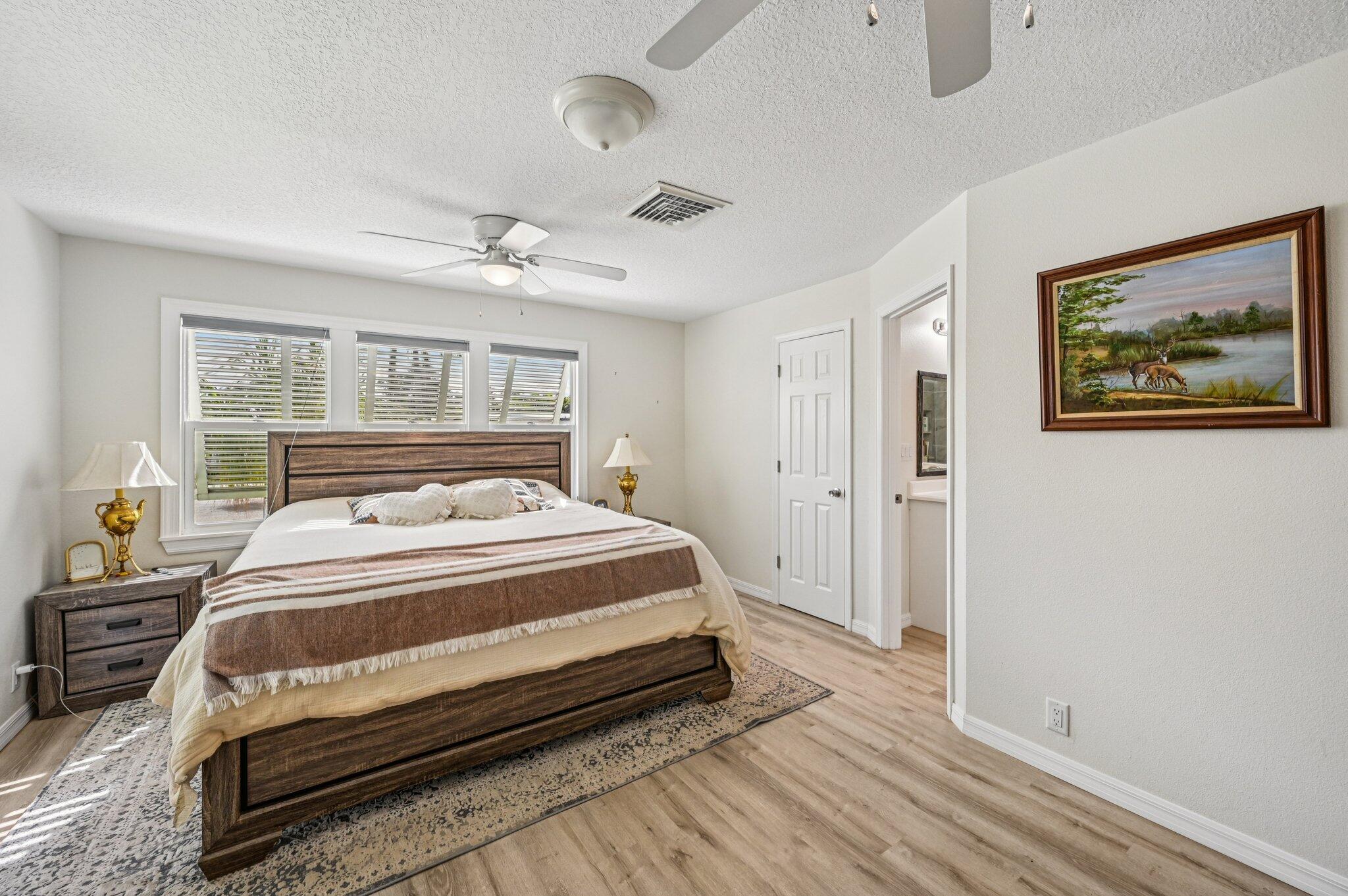 251 Southeast Paradise Place Stuart, FL 34997 - Photo 12 of 39 a bedroom with a bed and a painting on the wall