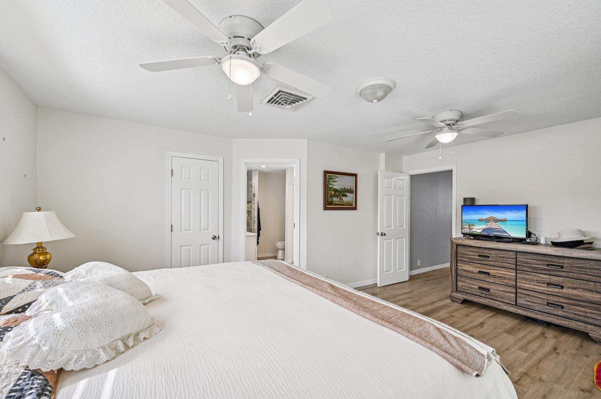 251 Southeast Paradise Place Stuart, FL 34997 - Photo 13 of 39 a bedroom with a large bed and a chandelier