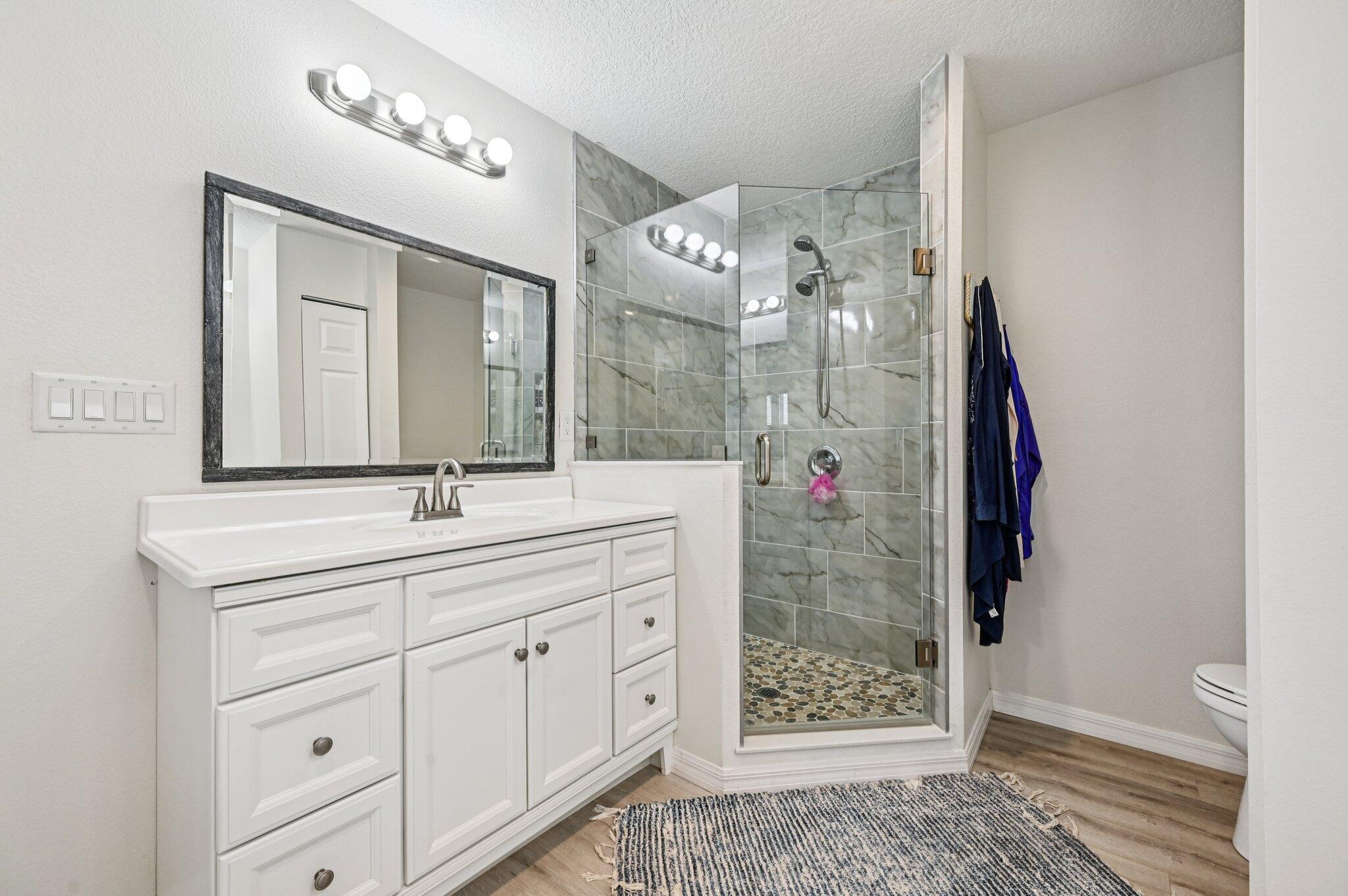 251 Southeast Paradise Place Stuart, FL 34997 - Photo 14 of 39 a bathroom with a shower a sink and a mirror