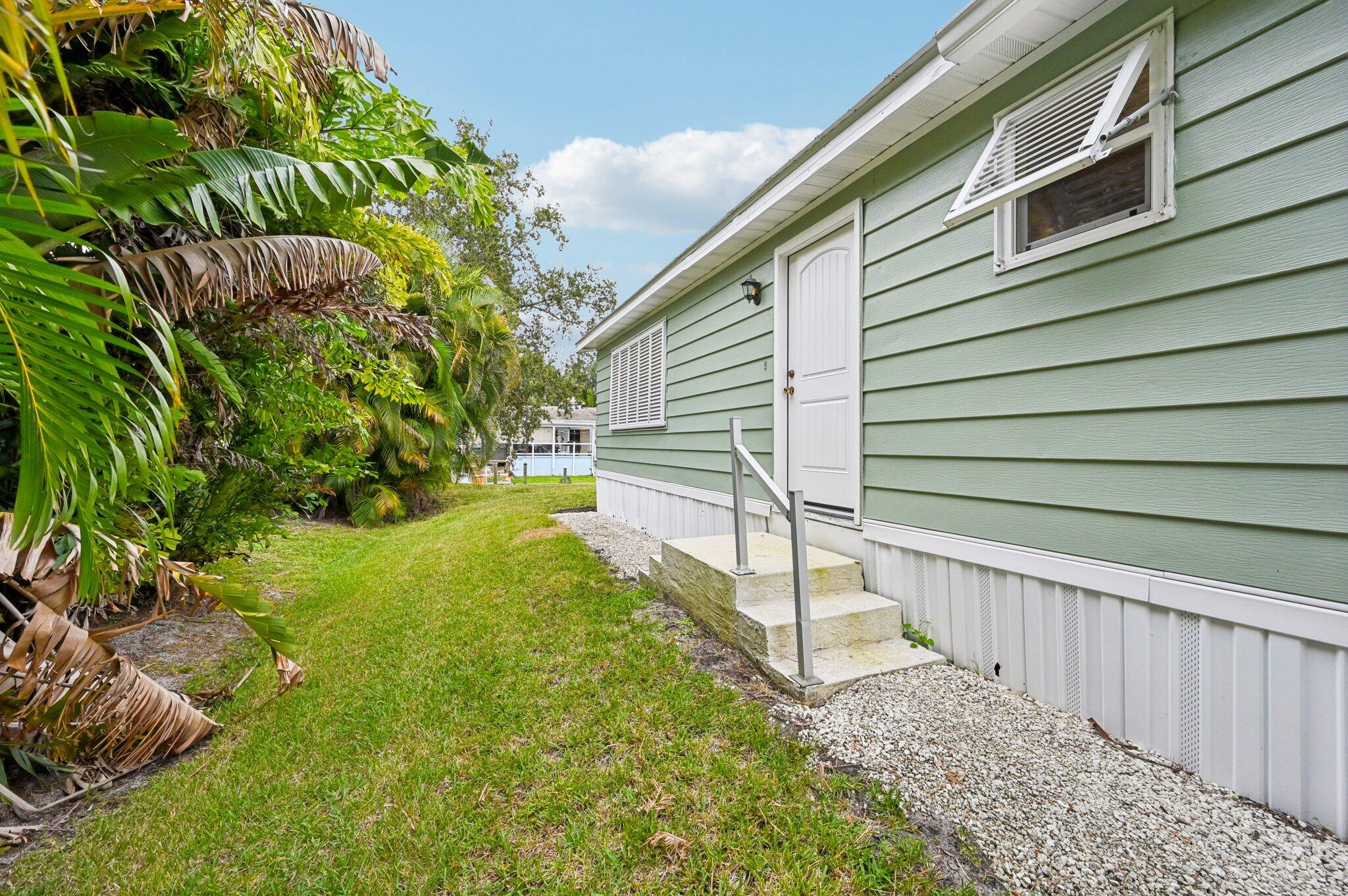 251 Southeast Paradise Place Stuart, FL 34997 - Photo 23 of 39 a yellow house with a yard and sitting area
