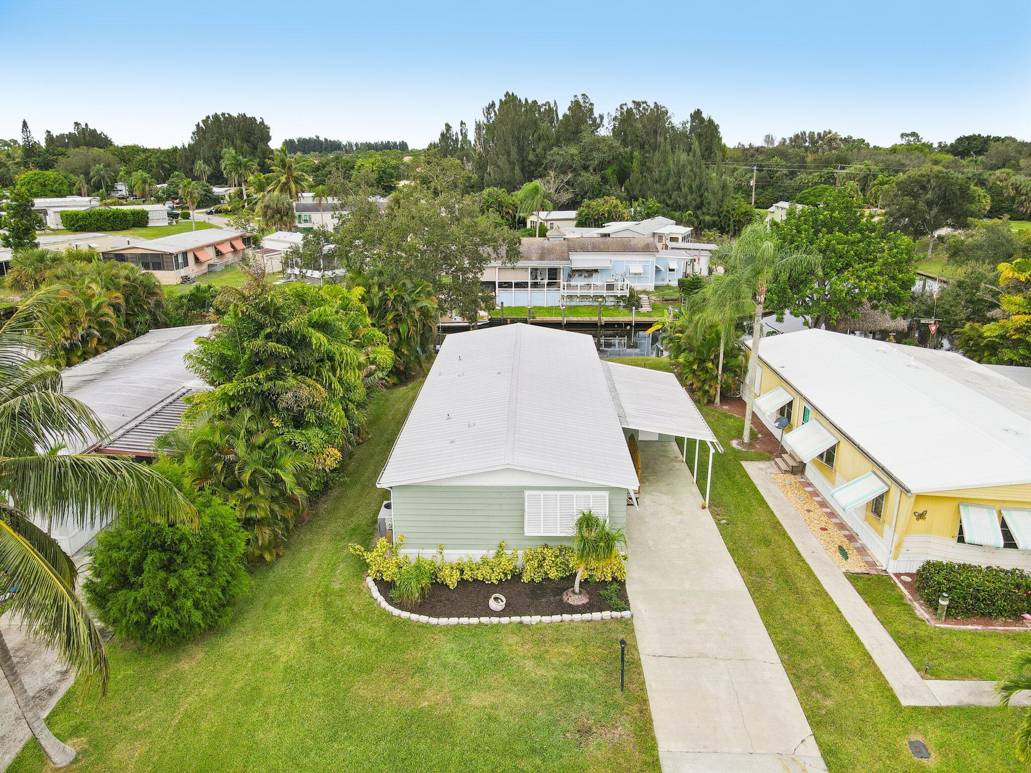 251 Southeast Paradise Place Stuart, FL 34997 - Photo 26 of 39 a view of a swimming pool with a garden and trees