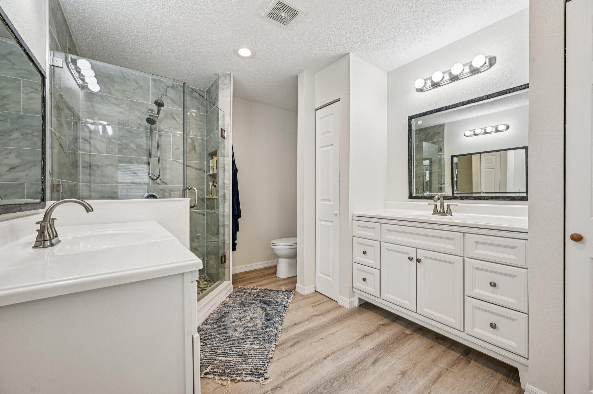 251 Southeast Paradise Place Stuart, FL 34997 - Photo 4 of 39 a spacious bathroom with a double vanity sink mirror and bathtub