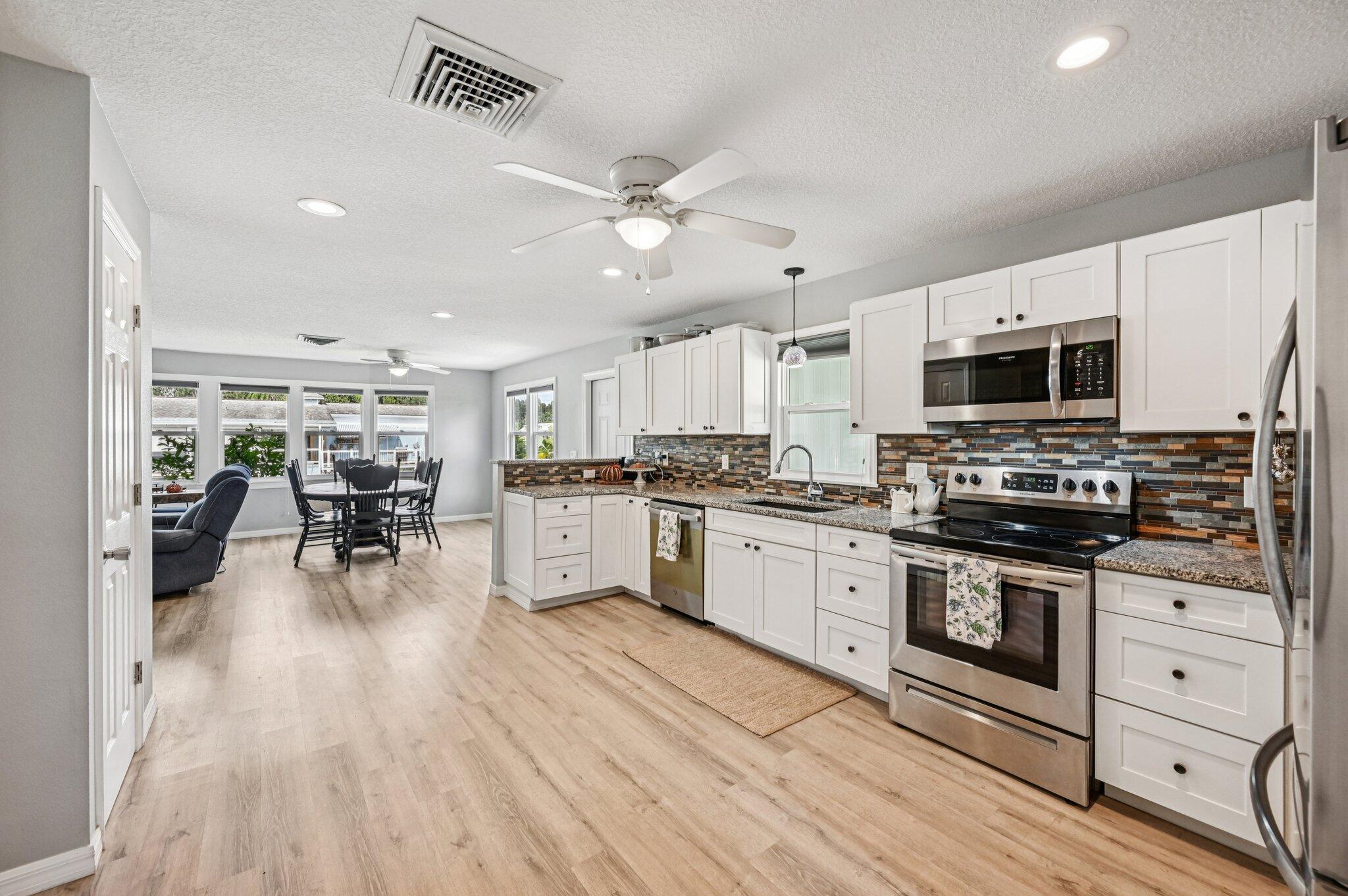 251 Southeast Paradise Place Stuart, FL 34997 - Photo 10 of 39 a kitchen with white cabinets and appliances
