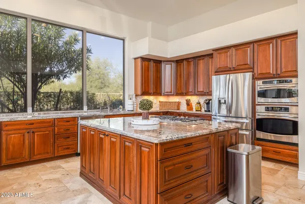 a kitchen with stainless steel appliances granite countertop a refrigerator a stove a sink and dishwasher