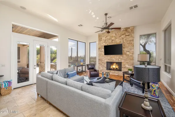 a living room with fireplace furniture and a large window