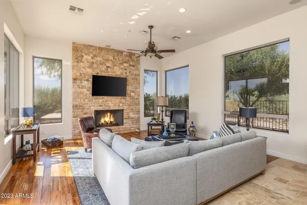 a living room with furniture kitchen view and a large window
