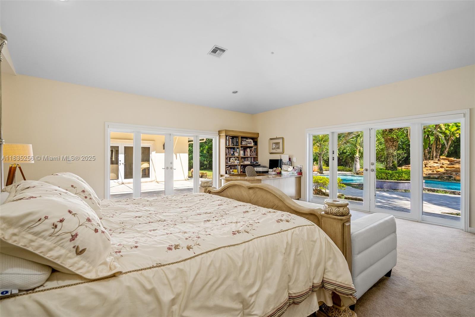 10735 Southwest 58th Avenue Pinecrest, FL 33156 - Photo 36 of 75 a bed sitting in a bedroom next to a large window with balcony view