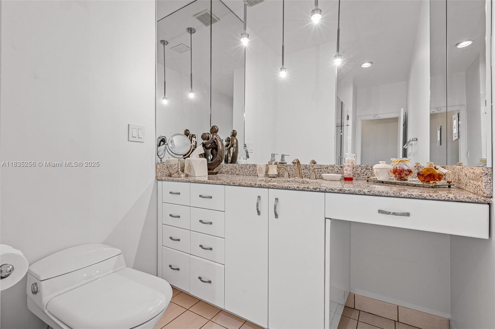 10735 Southwest 58th Avenue Pinecrest, FL 33156 - Photo 50 of 75 a bathroom with a toilet a sink and mirror
