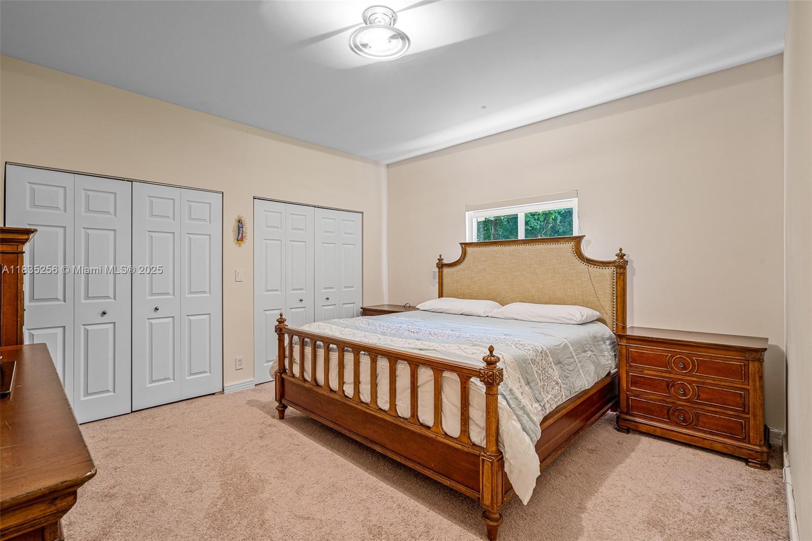 10735 Southwest 58th Avenue Pinecrest, FL 33156 - Photo 55 of 75 a bedroom with a bed and a chandelier