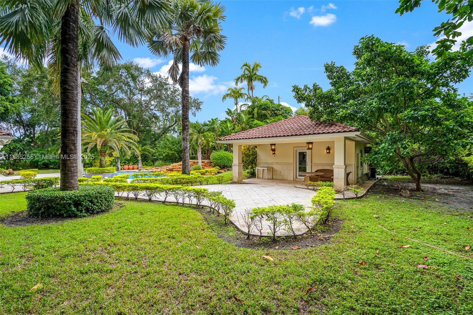 10735 Southwest 58th Avenue Pinecrest, FL 33156 - Photo 69 of 75 a view of a house with swimming pool and a garden