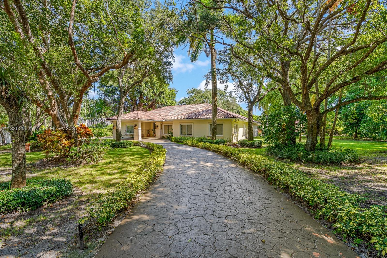 10735 Southwest 58th Avenue Pinecrest, FL 33156 - Photo 7 of 75 a front view of a house with a yard and fountain in middle