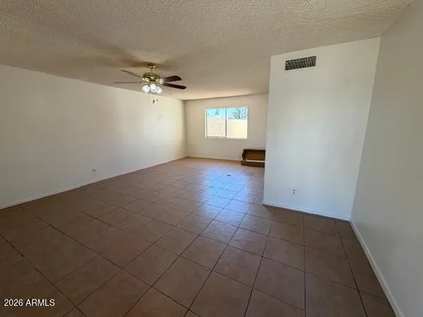 an empty room with windows and fan