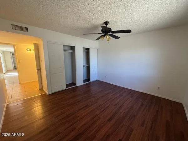 a view of empty room with wooden floor