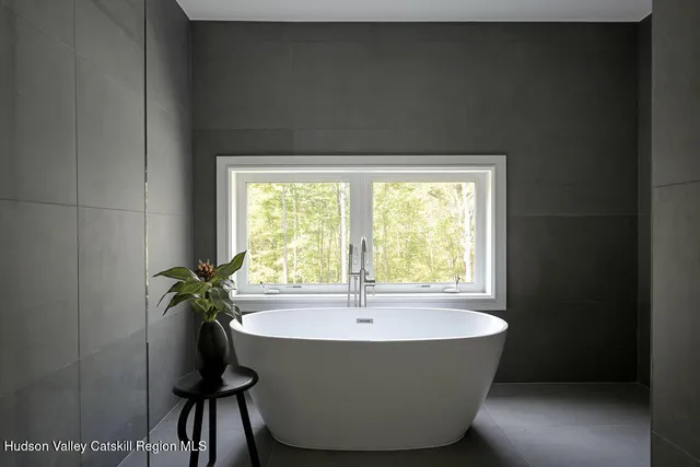 a white bath tub sitting in a bathroom next to a window