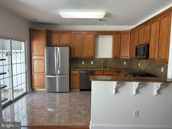 a kitchen with a refrigerator a microwave a sink and cabinets