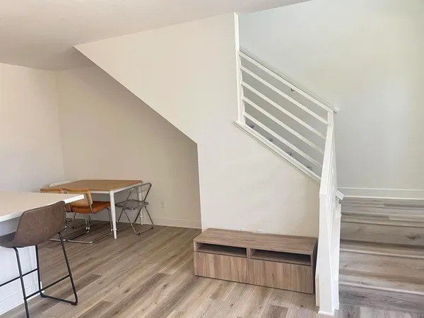 a view of a livingroom with wooden floor and a hallway