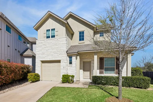 a front view of a house with a garden and plants