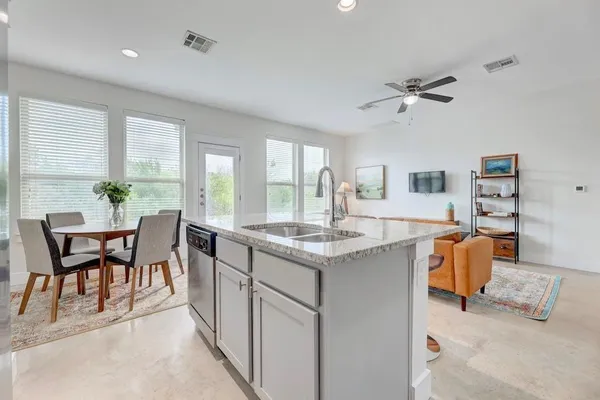 a dining hall with stainless steel appliances granite countertop furniture and a large window
