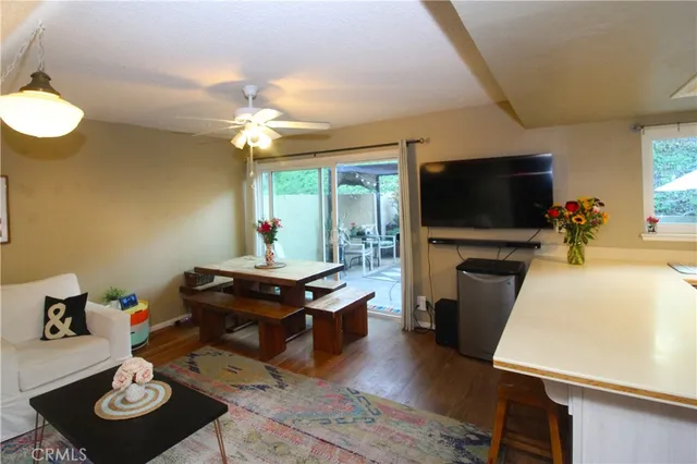 a living room with stainless steel appliances kitchen island furniture and a flat screen tv