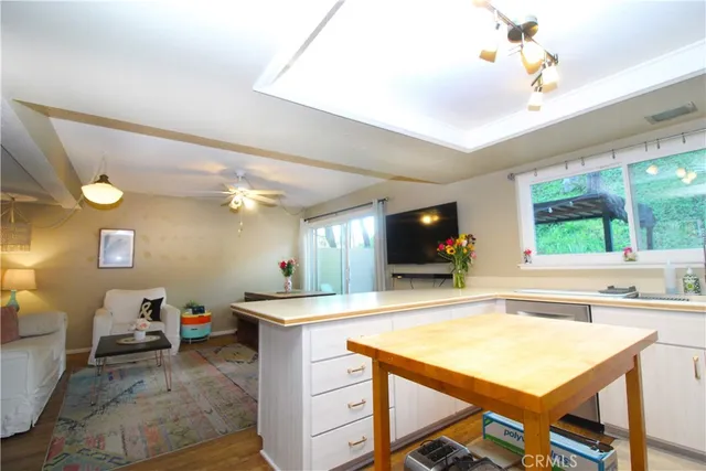 a living room with a flat screen tv and kitchen view