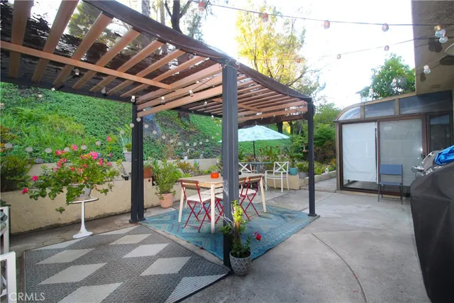 a view of a patio with a table and chairs under an umbrella
