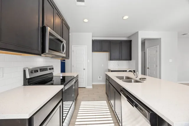 a kitchen with a stove a sink and a microwave