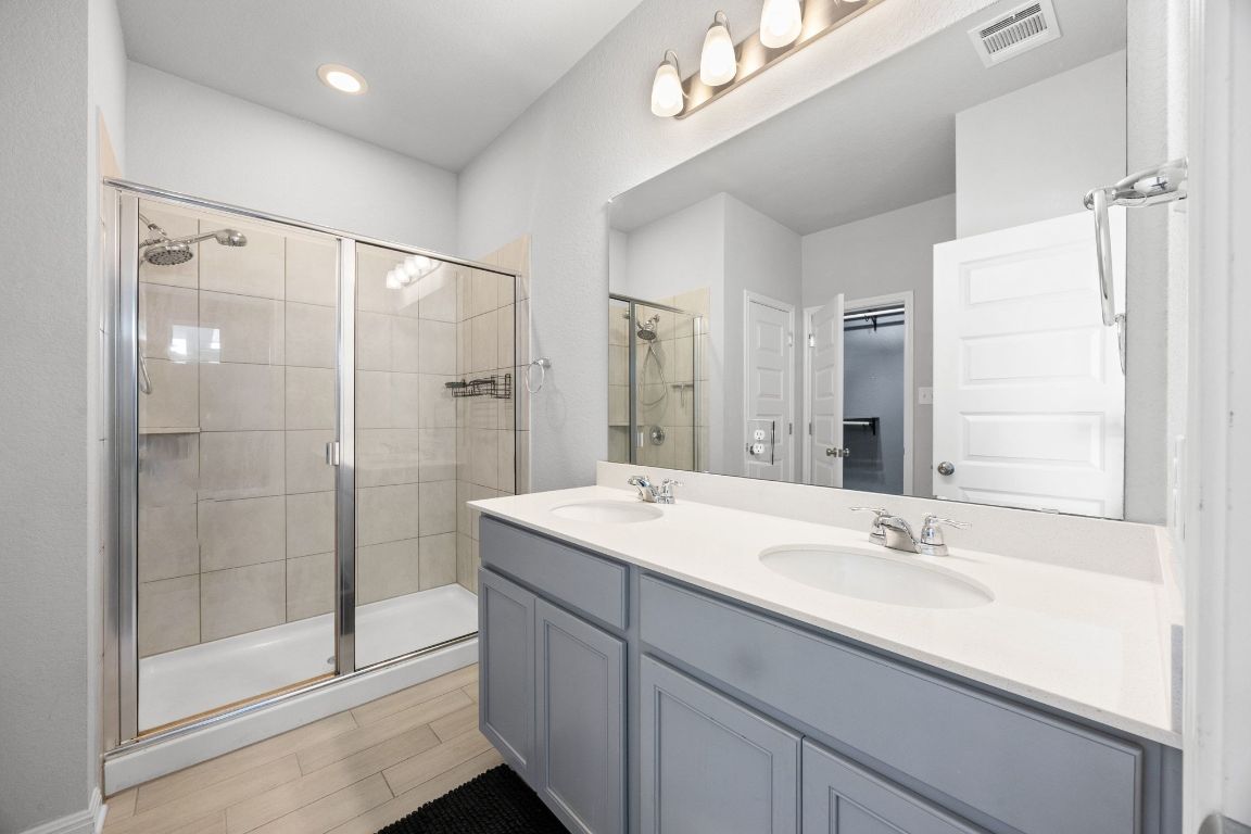 225 Unforgiven Lane Jarrell, TX 76537 - Photo 13 of 27 a bathroom with a shower sink and mirror
