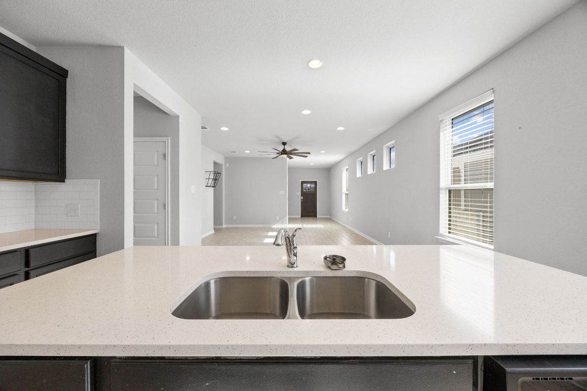 225 Unforgiven Lane Jarrell, TX 76537 - Photo 26 of 27 a kitchen with kitchen island a sink a counter top space and a window
