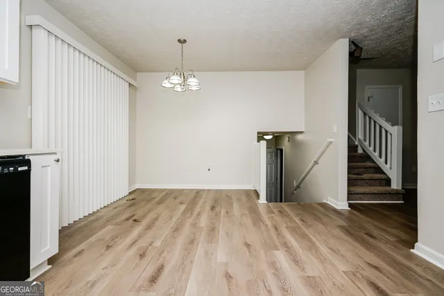 a view of a livingroom with wooden floor and stairs