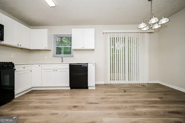 a kitchen with a stove cabinets and wooden floor