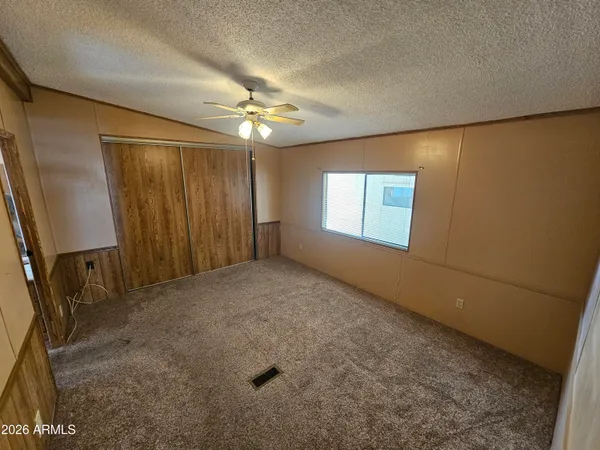 en empty room with windows and fan