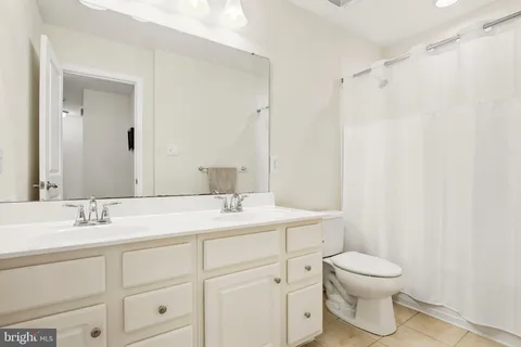 a bathroom with a toilet sink a mirror and vanity