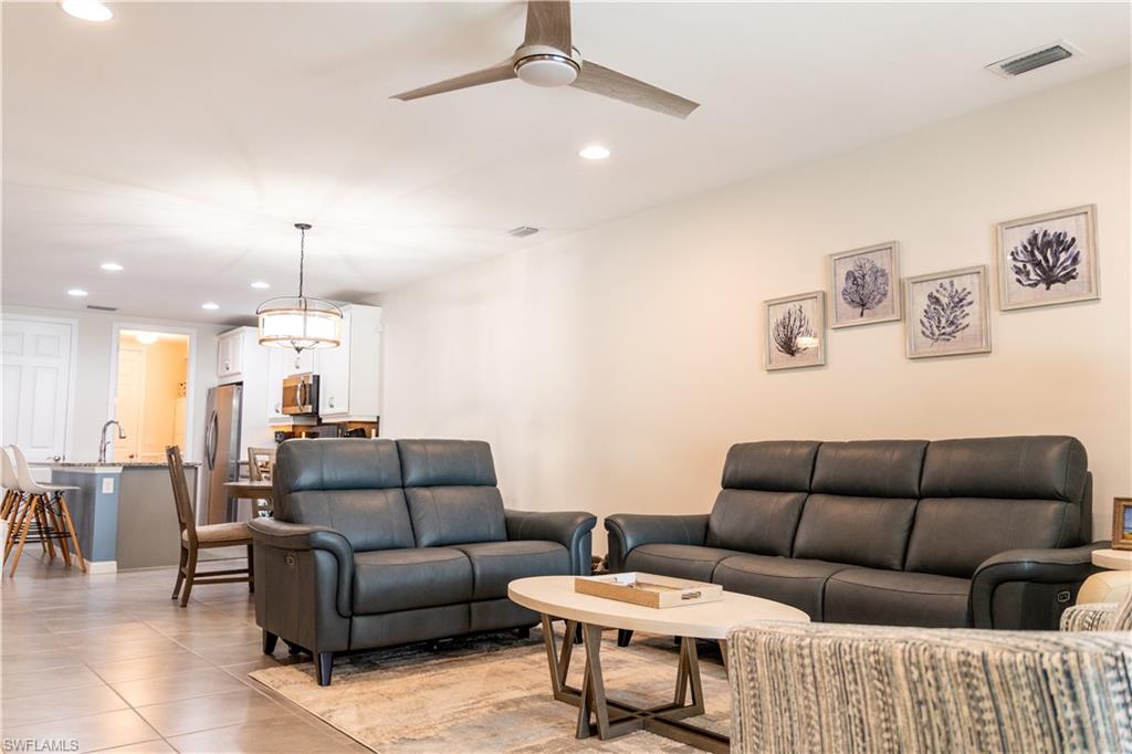 14888 Edgewater Circle Naples, FL 34114 - Photo 15 of 33 a living room with furniture a ceiling fan and a rug