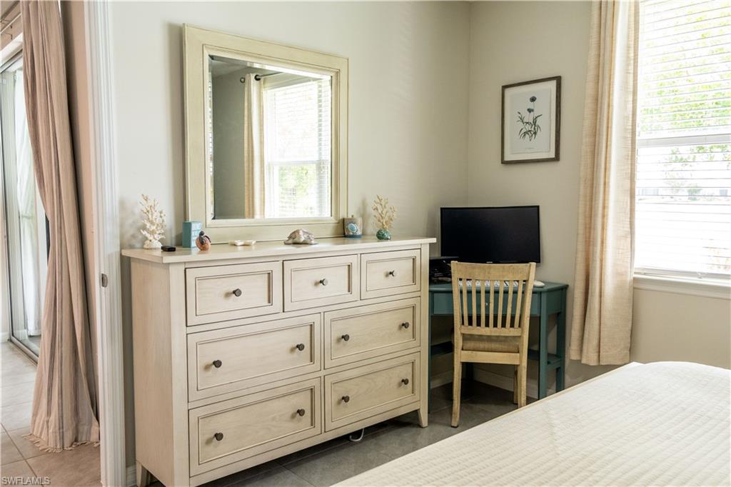 14888 Edgewater Circle Naples, FL 34114 - Photo 28 of 33 a room with a chair and a flat screen tv