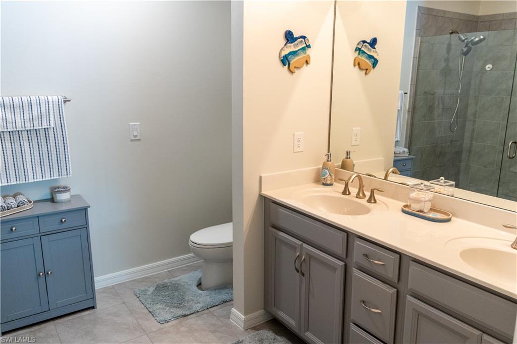 14888 Edgewater Circle Naples, FL 34114 - Photo 6 of 33 a bathroom with a sink toilet and mirror