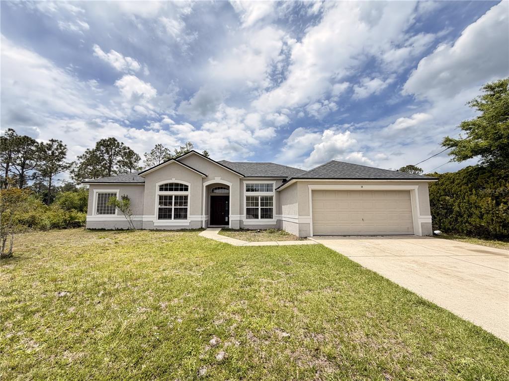 34 Roxanne Lane Palm Coast, FL 32164 - Photo 1 of 1 a front view of house with yard and trees