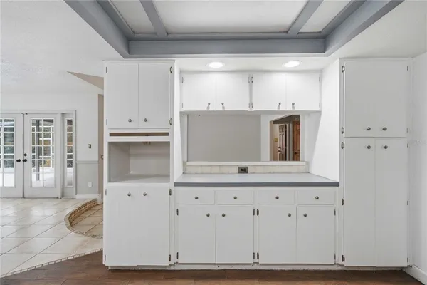 a open white kitchen with center island and stainless steel appliances