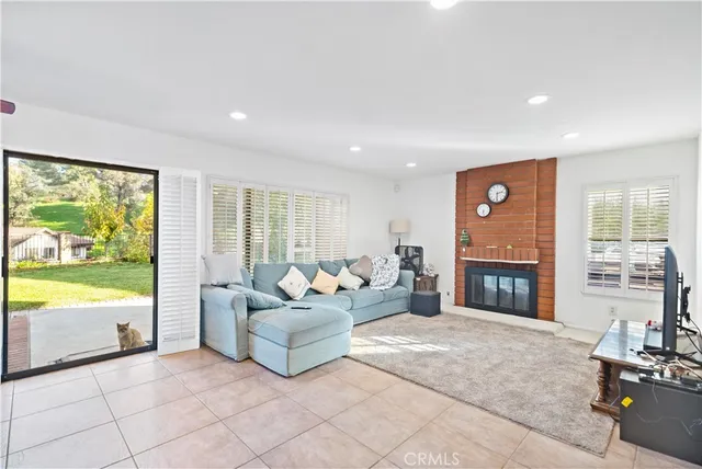 a living room with fireplace furniture and a large window