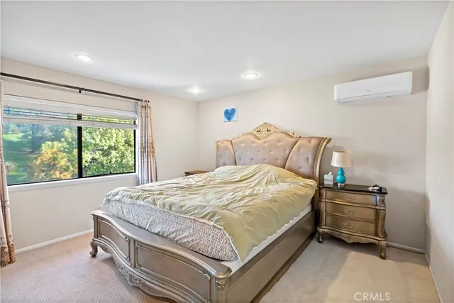 a bed sitting in a spacious bedroom next to a window