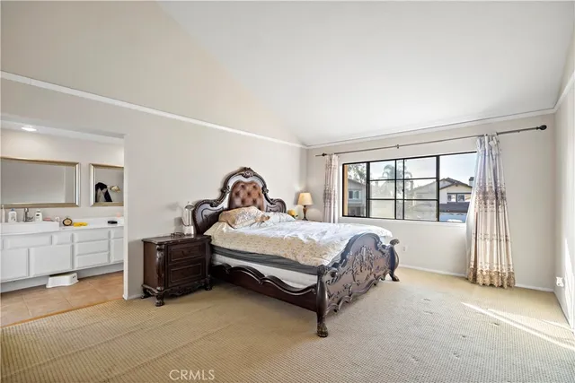 a bed sitting in a spacious bedroom next to a window