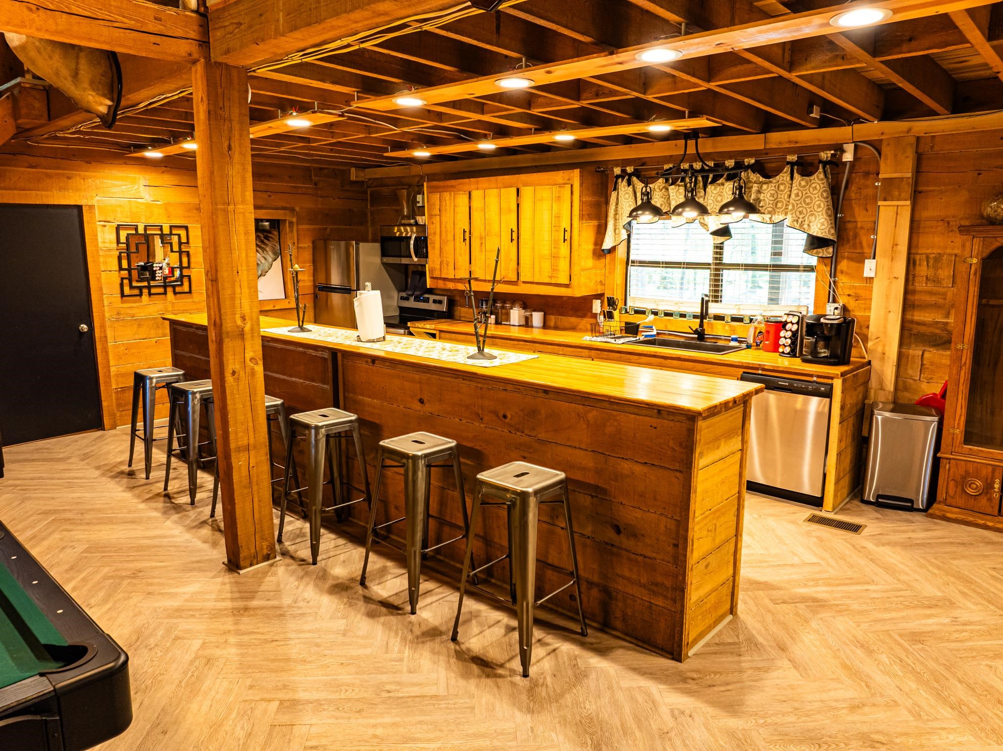 280 Fields Road Dukedom, TN 38226 - Photo 25 of 40 Kitchen featuring wood walls, a kitchen breakfast bar, stainless steel appliances, parquet floors, and wood finish cabinets