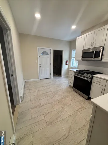 a large kitchen with cabinets and stainless steel appliances