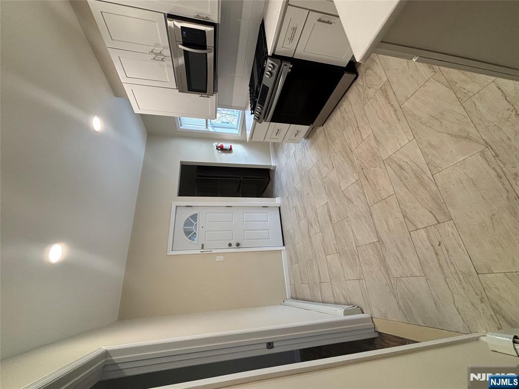 42 Maple Avenue, Unit 2 Irvington, NJ 07111 - Photo 2 of 10 a large kitchen with cabinets and stainless steel appliances