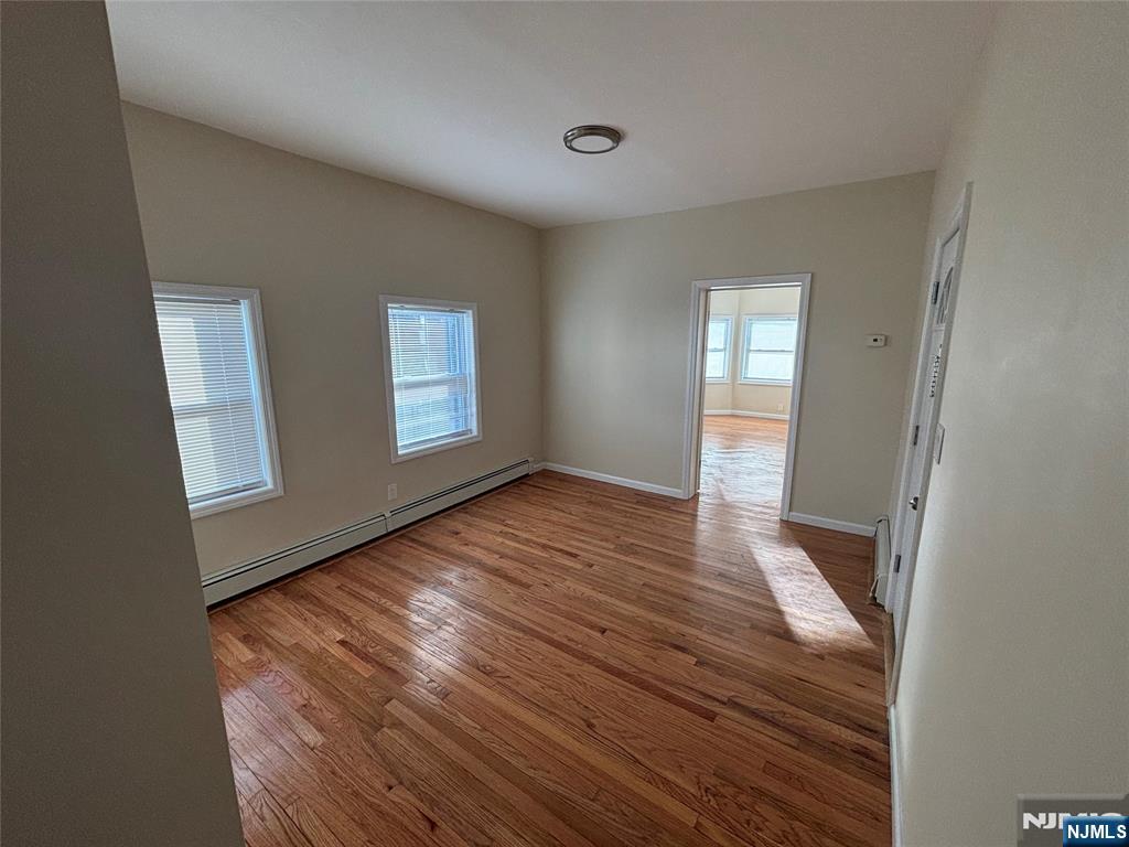 42 Maple Avenue, Unit 2 Irvington, NJ 07111 - Photo 8 of 10 a view of an empty room with wooden floor and a window