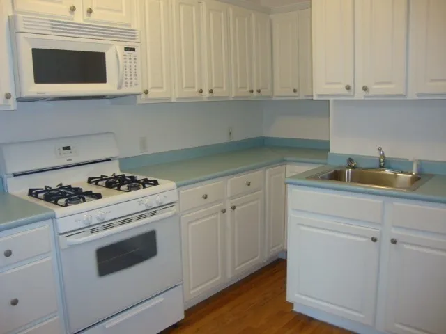 a kitchen with white cabinets and appliances