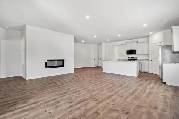 a view of kitchen with granite countertop cabinets and refrigerator