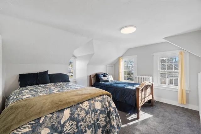 a bedroom with two beds and a large window