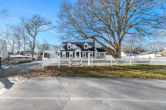 a view of residential houses with yard and road