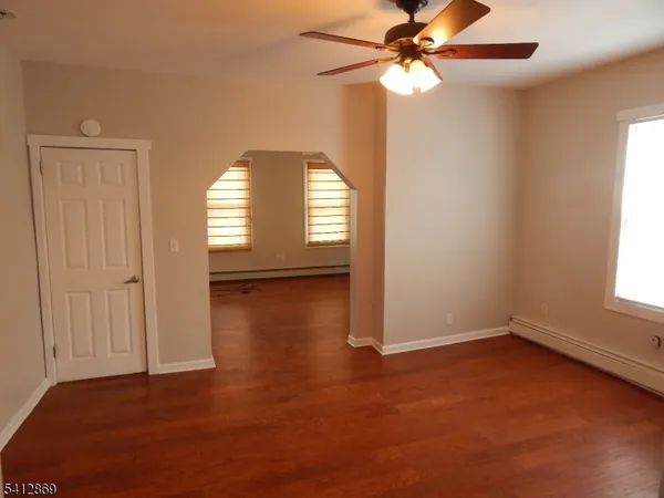 an empty room with windows and fan