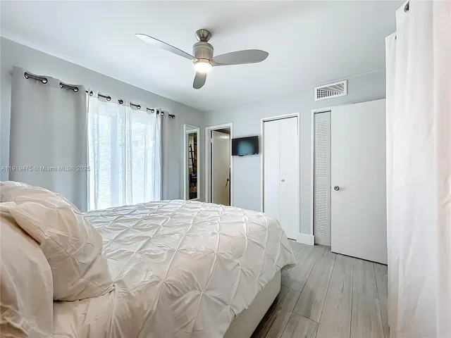 a spacious bedroom with a bed and a large mirror